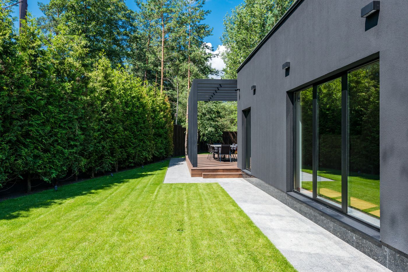 Landscaped backyard with lawn, hedging and a sheltered outdoor dining area